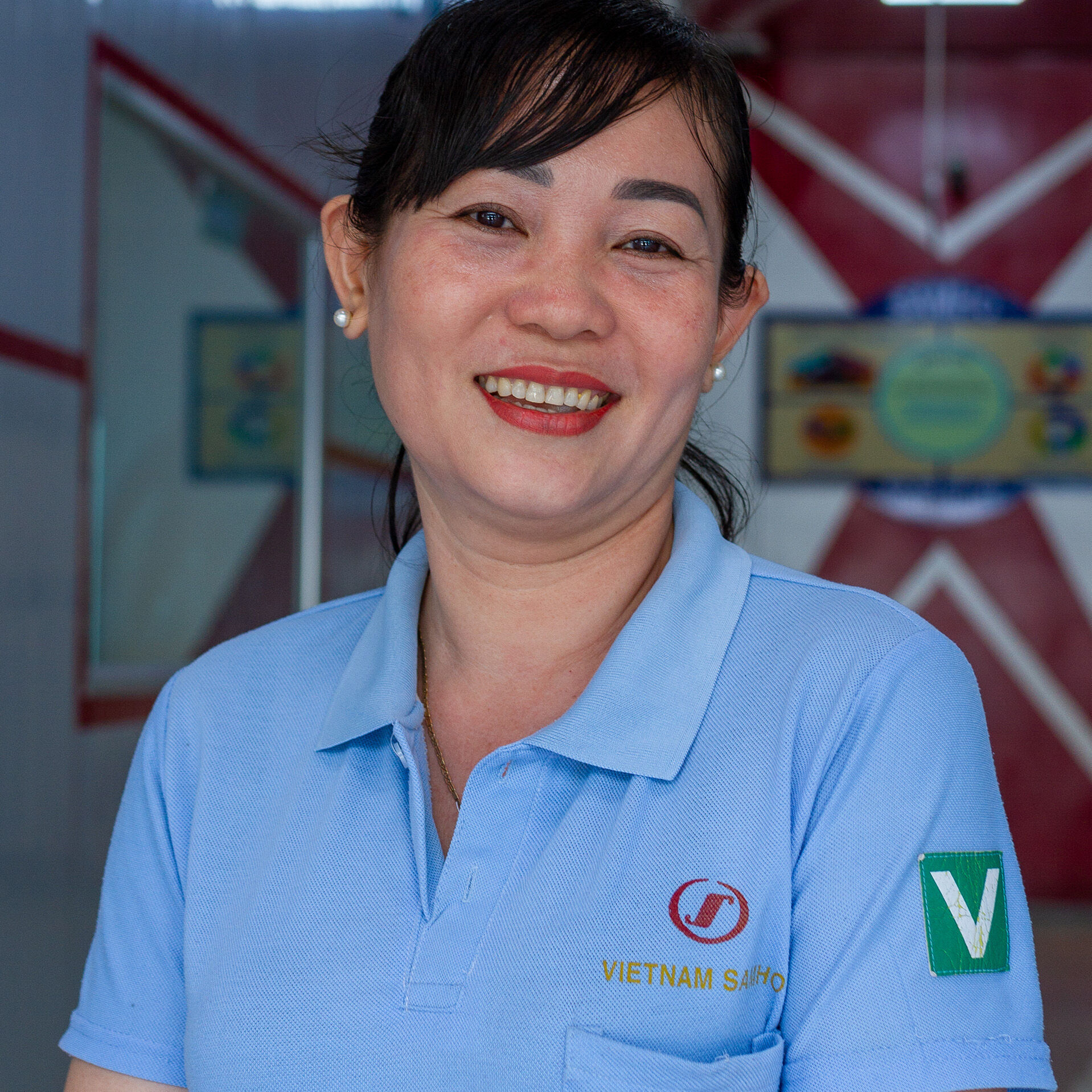 Female factory worker smiling and posing for photo